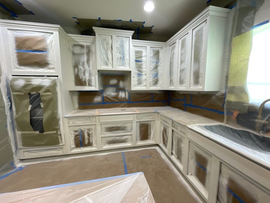 image of the kitchen taped up and new wall paint on cabinets