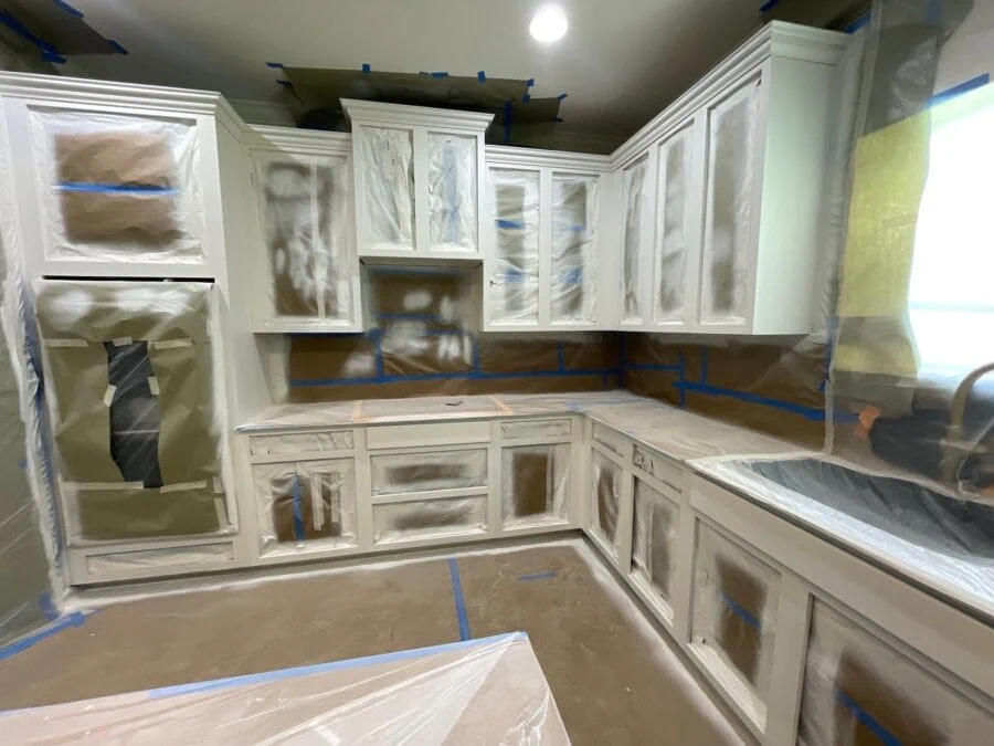 image of the kitchen taped up and new wall paint on cabinets