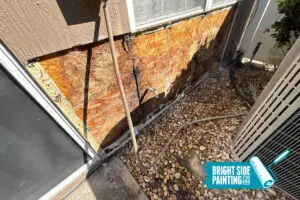 image of damaged stucco on the side of a house with a bright side painting logo