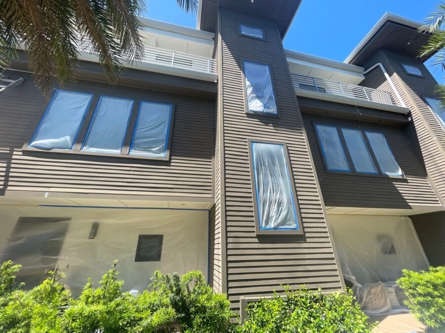 Townhome exterior with windows masked off during exterior prep and painting in Jacksonville
