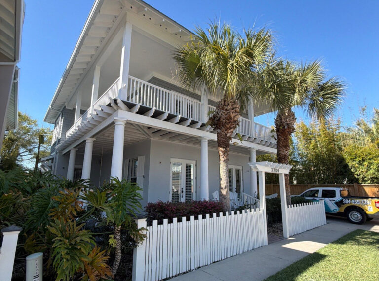 exterior of two story coastal house featuring updated stucco paint job